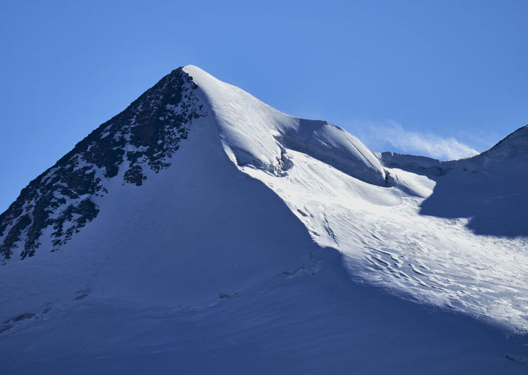 Scenic view of snowcapped mountains against clear blue sky