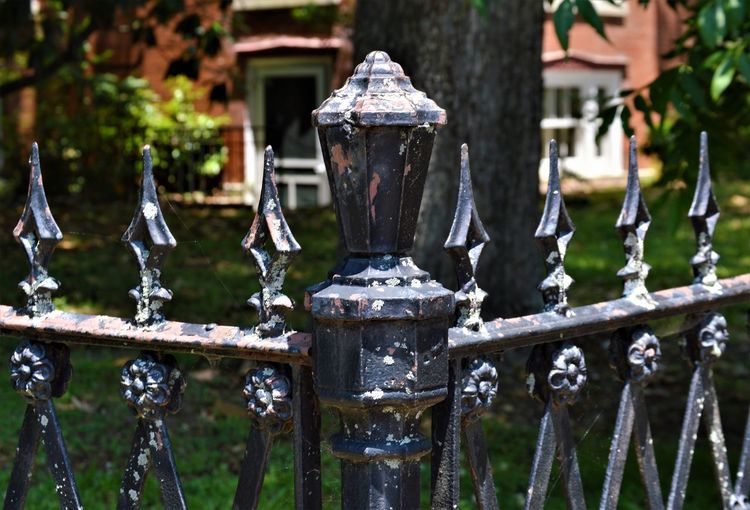 Close-up of wrought iron fence corner with finial