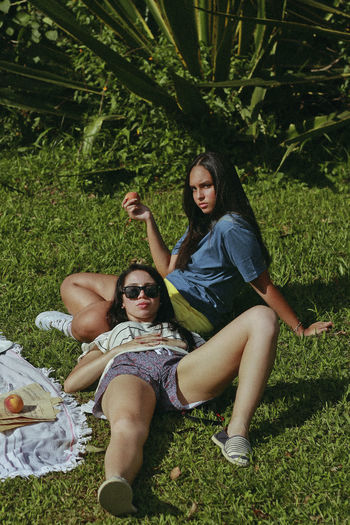 YOUNG WOMAN WEARING SUNGLASSES ON PLANT