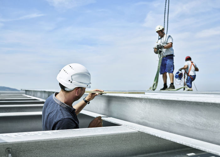 Construction worker checking steel girder