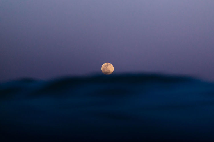 Full moon over the sea waves on the beach