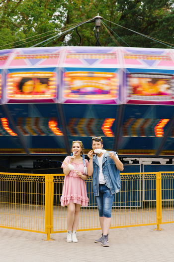 Happy couple in love enjoying each other in an amusement park. a guy and a girl eating cotton candy