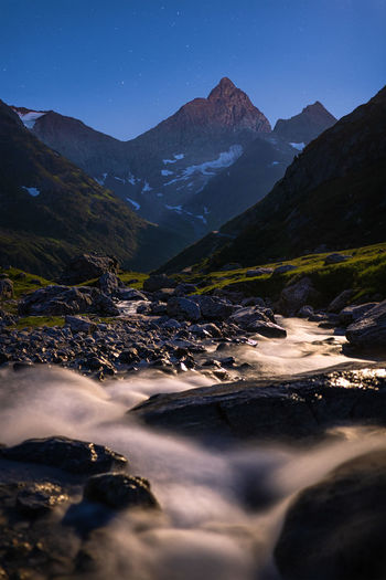 Long time exposure of the flowing water of a creek in the swiss alps at night