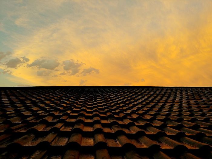 A view of passing storm clouds just before sunset from the top of a tiled roof in johannesburg. 