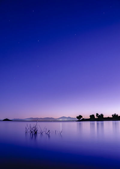 SCENIC VIEW OF LAKE AGAINST BLUE SKY DURING NIGHT
