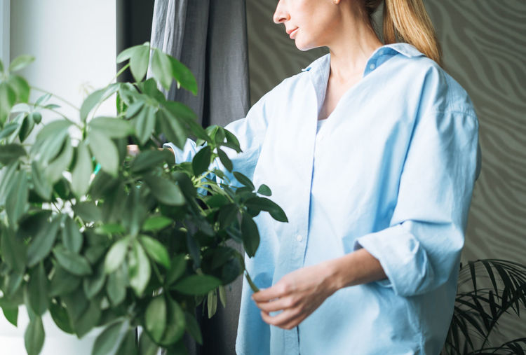 Midsection of female doctor holding plant