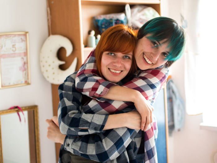 Portrait of smiling lesbian couple at home