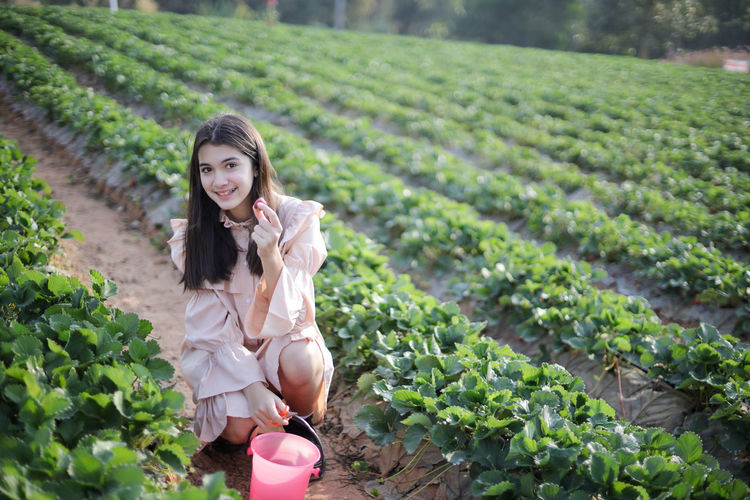 Portrait of smiling young woman standing in farm