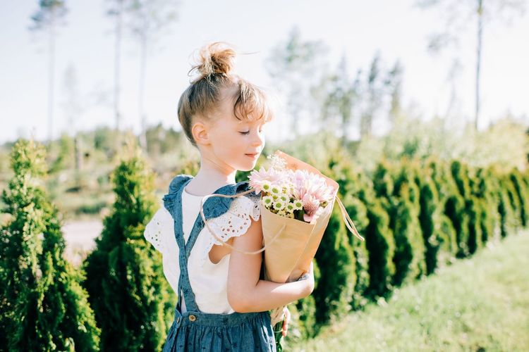 Portrait of a pretty young girl holding a beautiful bouquet of flowers