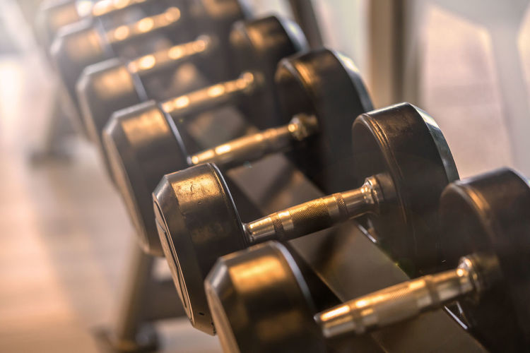 Close-up of dumbbells in row at gym