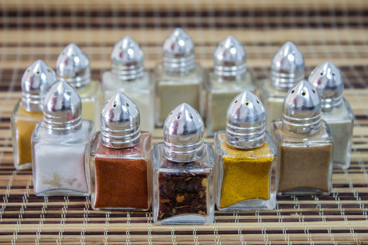 Close-up of spices arranged in glass containers on mat