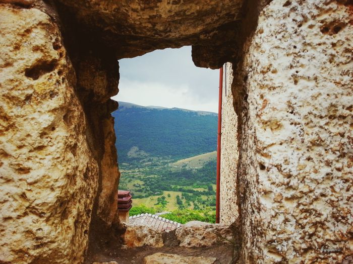 Scenic view of rocky mountains seen through window