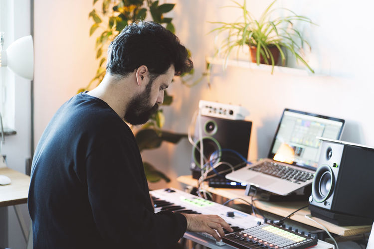 Male music composer using piano in studio