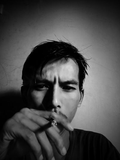 Portrait of young man smoking cigarette