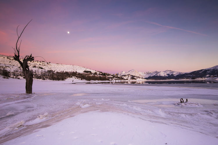 Frozen campotosto lake. winter landscape of the apennines in italy.