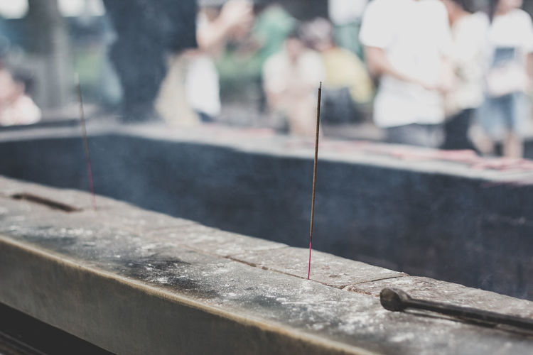 Close-up of burning incense stick in temple