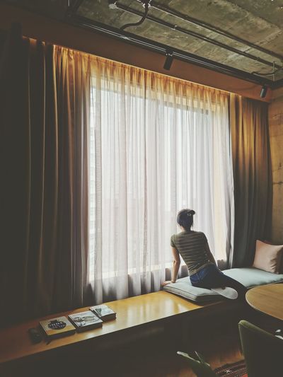 Rear view of woman sitting on table