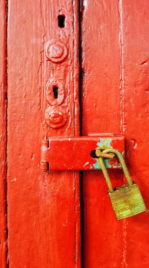 Old painted red door with padlock