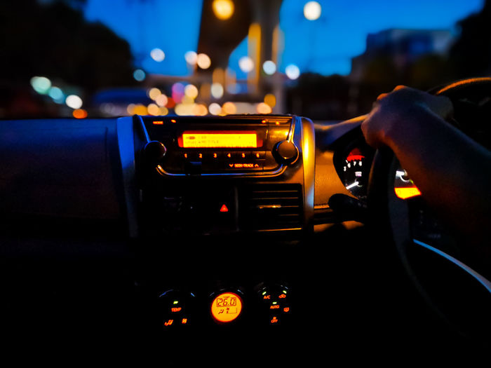 Close-up of hand holding illuminated car at night