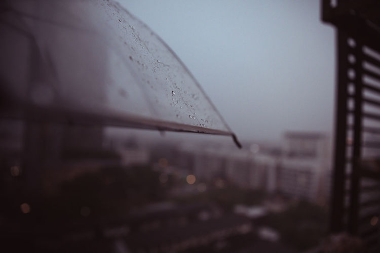 Close-up of wet umbrella against sky