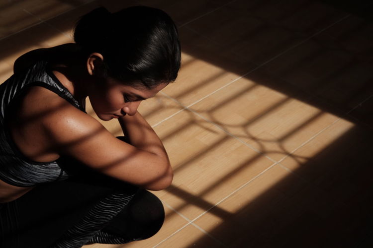 Side view of female athlete crouching on floor