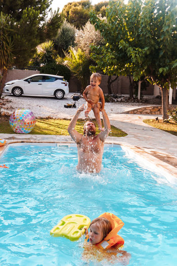 Dad swimming with his son in the pool in the yard