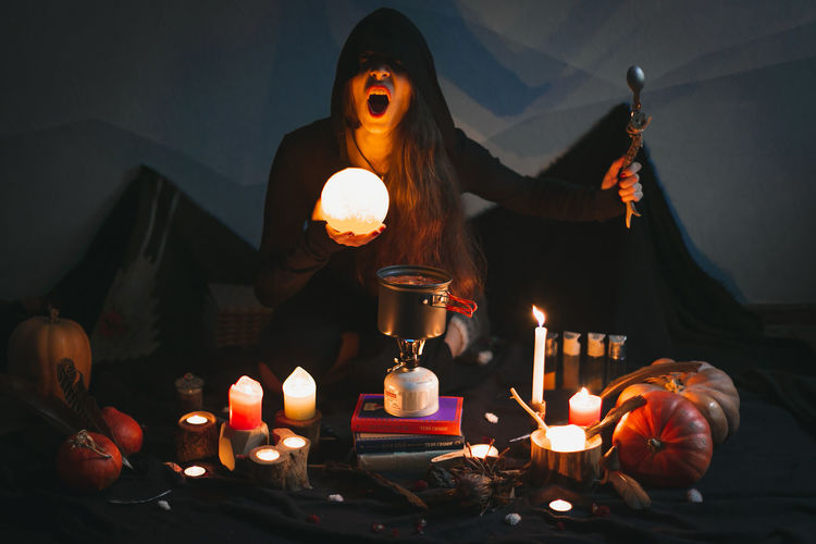 Close up woman casting spell with glowing ball and spoon portrait picture