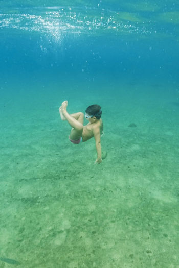 Full length of shirtless kid swimming in sea