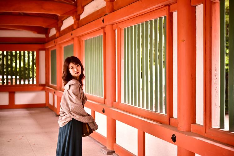 Portrait of smiling woman standing against shrine 