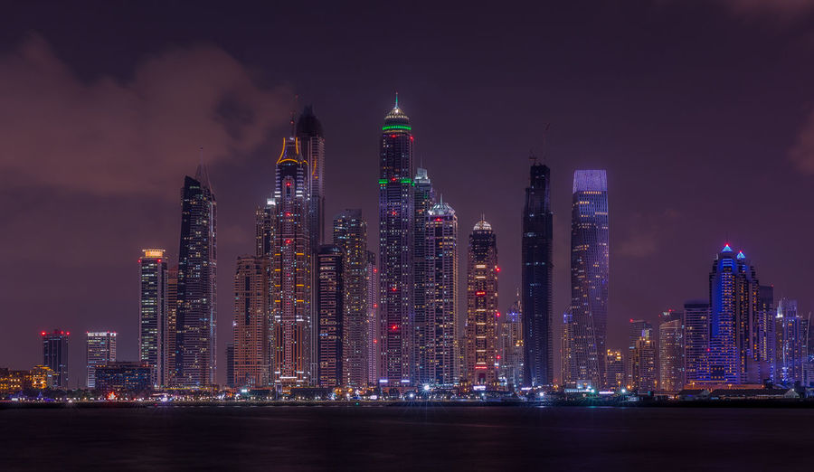 Illuminated cityscape against sky
