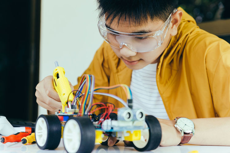 Teenager boy working on robotic toy