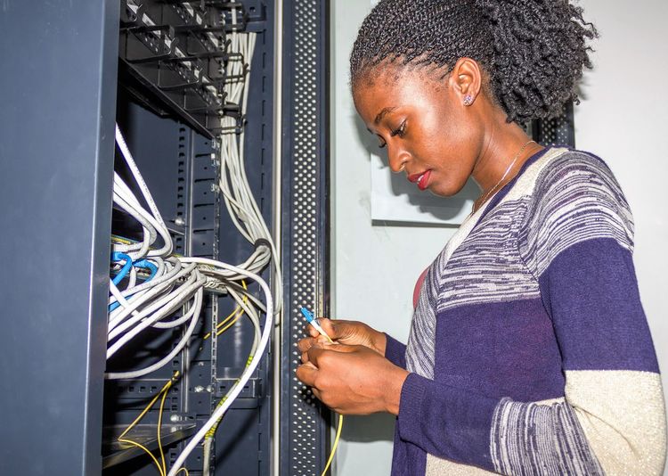Side view of woman working with wires