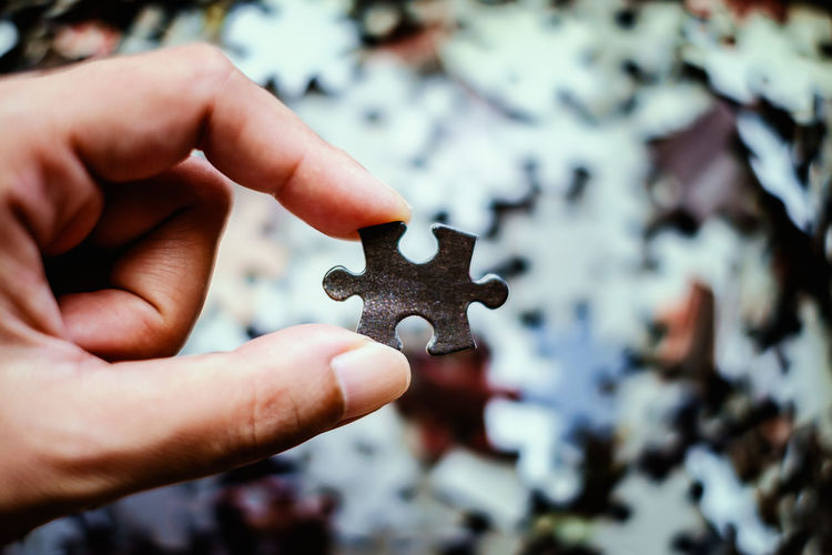 Cropped hand of person holding jigsaw puzzle
