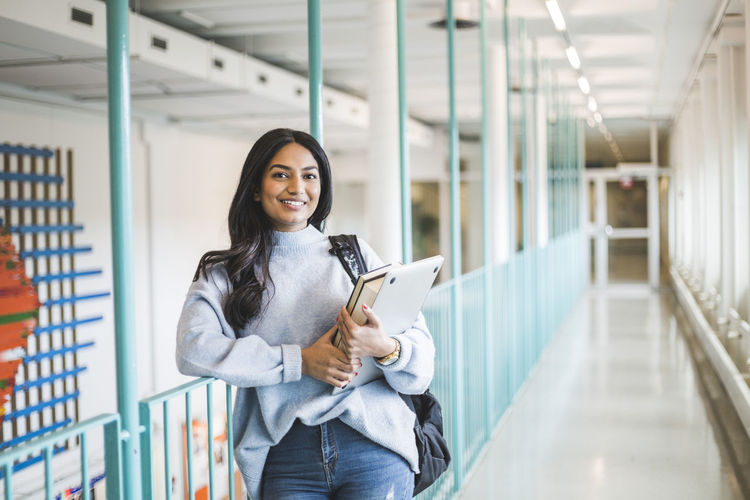 Portrait of young female student in corridor of university