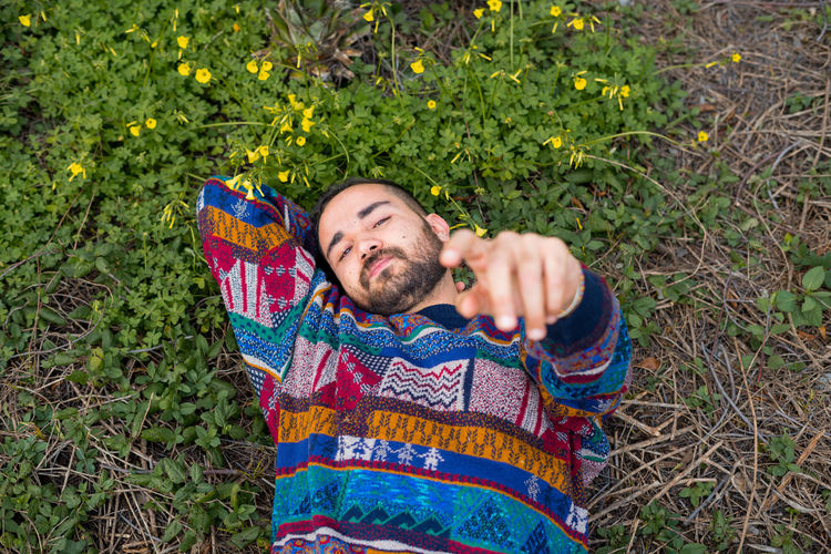 Moroccan man laying on the ground and holding his hand up to the camera