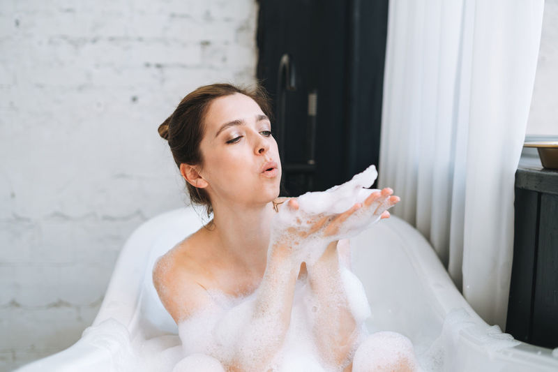 Woman Taking A Bubble Bath At Her Home