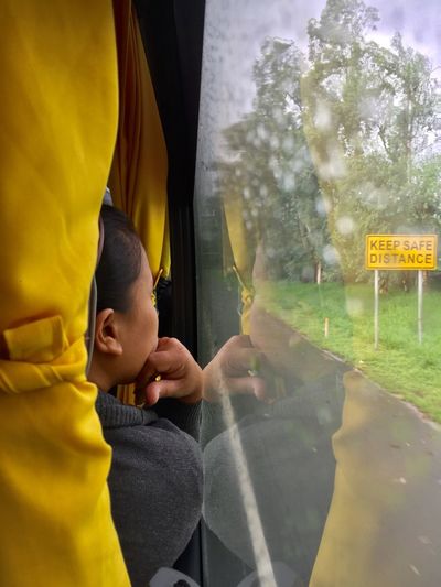 Boy looking through glass window