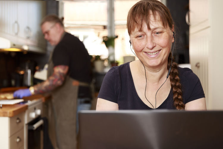 Smiling woman using laptop
