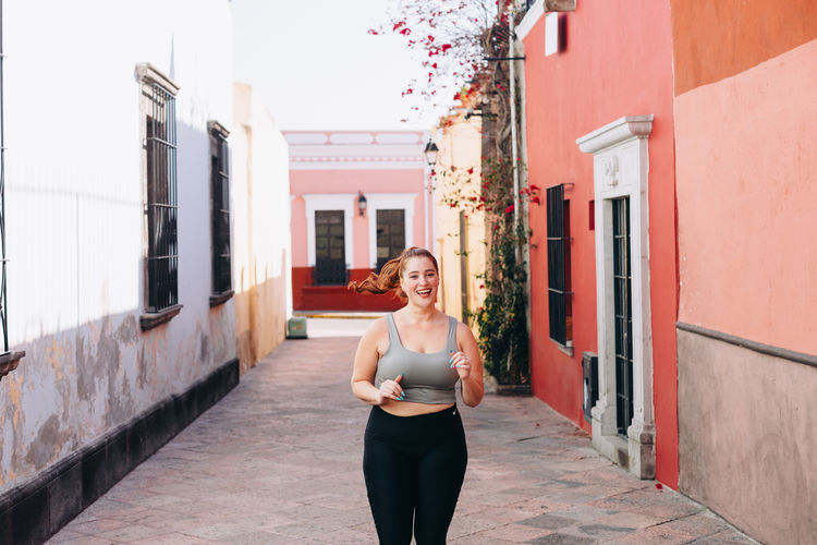 Young woman in sports clothing doing running and stretching exercises in queretaro, mexico