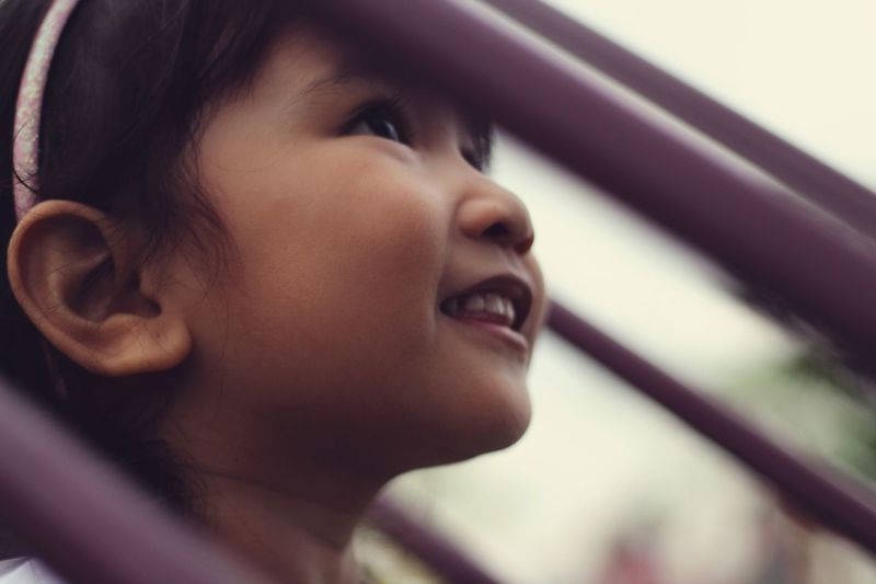 Close-up portrait of smiling girl looking away