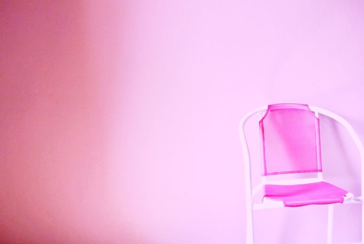 Close-up of empty glass on table against pink background