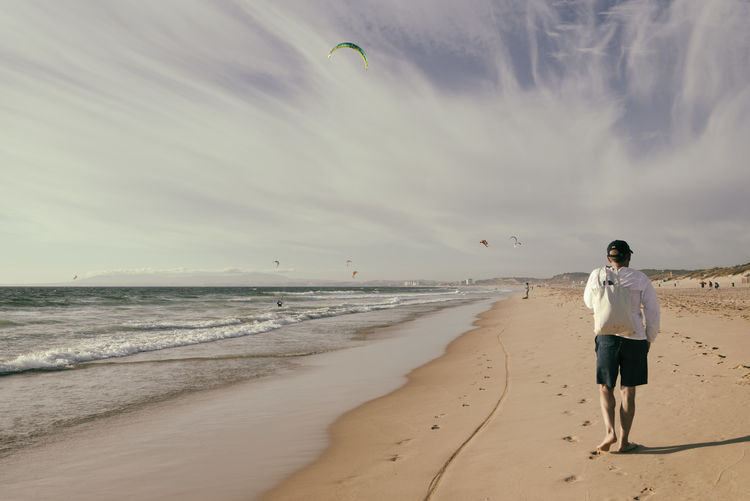 Full length of man walking at beach against sky