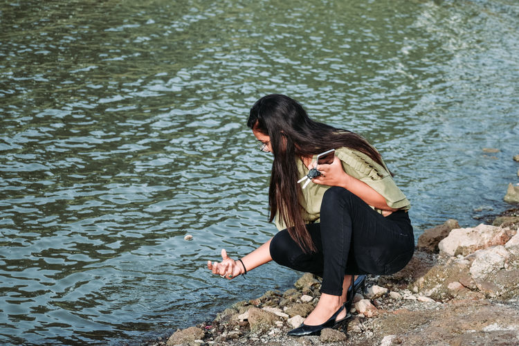 High angle view of woman sitting by lake