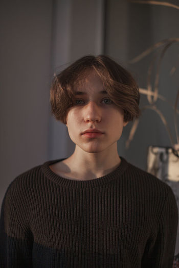 Portrait of teenage boy standing at home