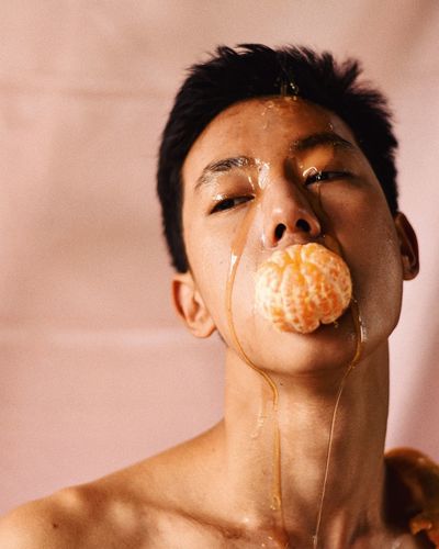 Close-up of man eating orange