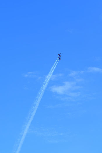 Low angle view of airshow flying against sky