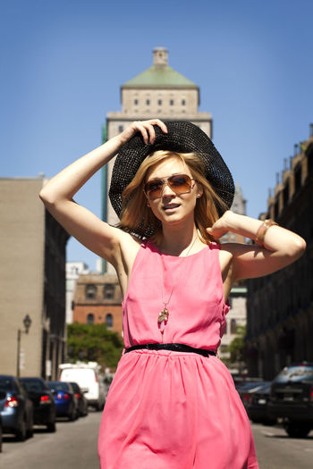 Woman in pink dress walking in city