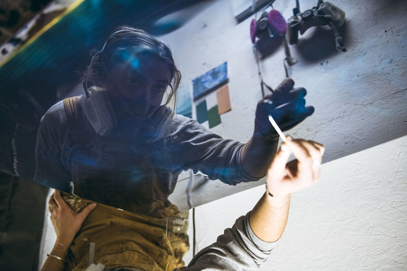 Reflection of female resin artist perfecting new artwork