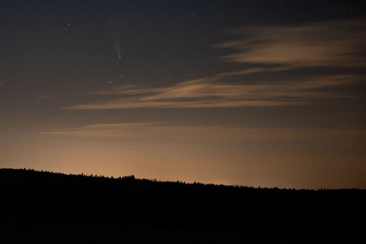 Scenic view of silhouette landscape  against sky at night with the comet neowise