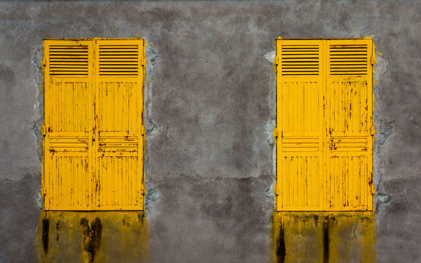 Close-up of yellow doors on building wall